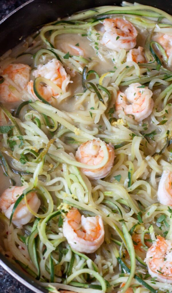 a pan of zucchini noodles and shrimp.