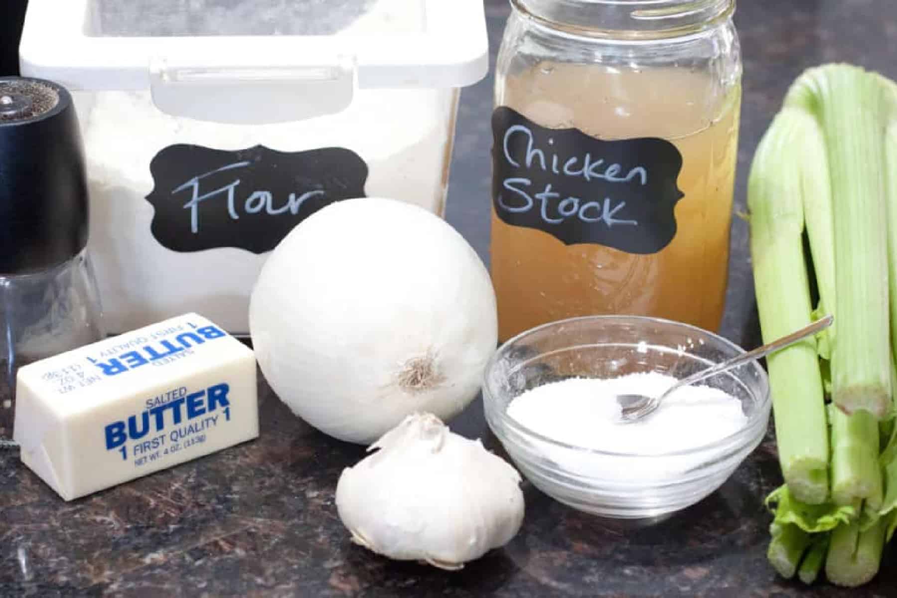 containers of labeled ingredients with flour, chicken stock, butter, onion, garlic, salt, and fresh celery.