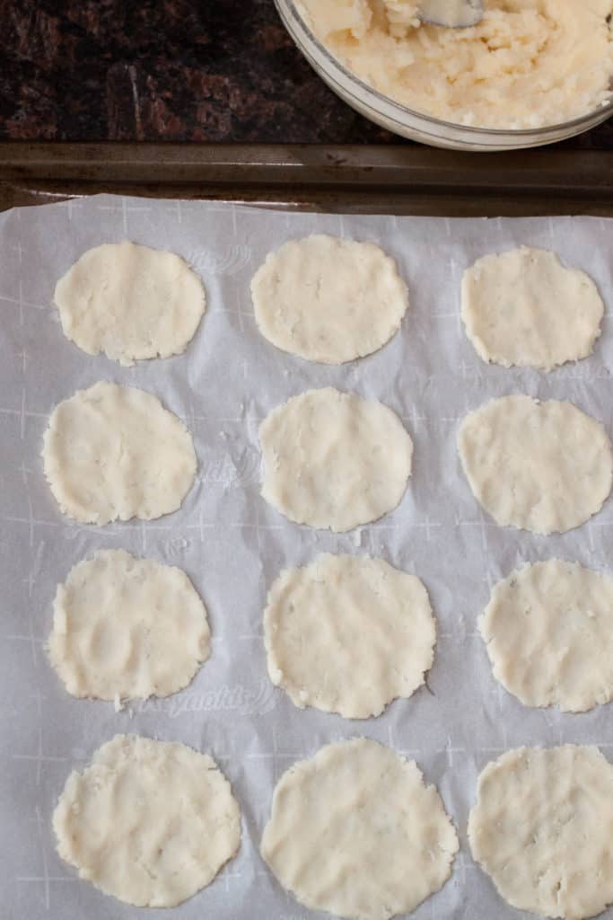 mashed potatoes flat on a baking sheet on parchment paper