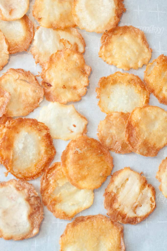 fresh made potato chips on parchment paper.