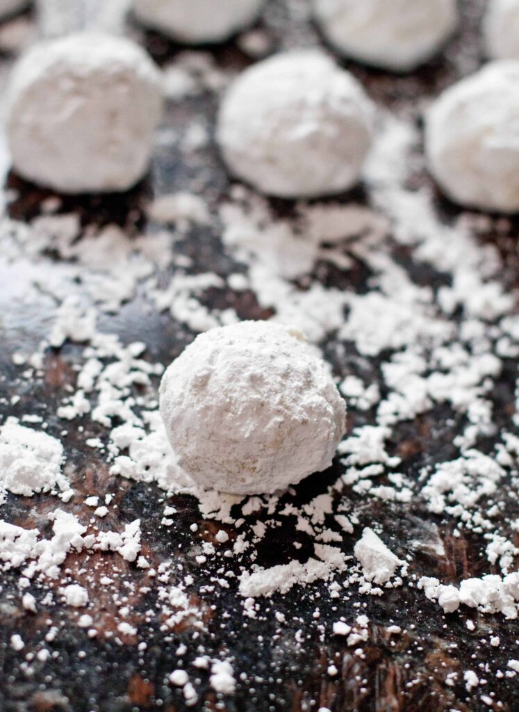 a sugar coated counter and white butter ball cookies.