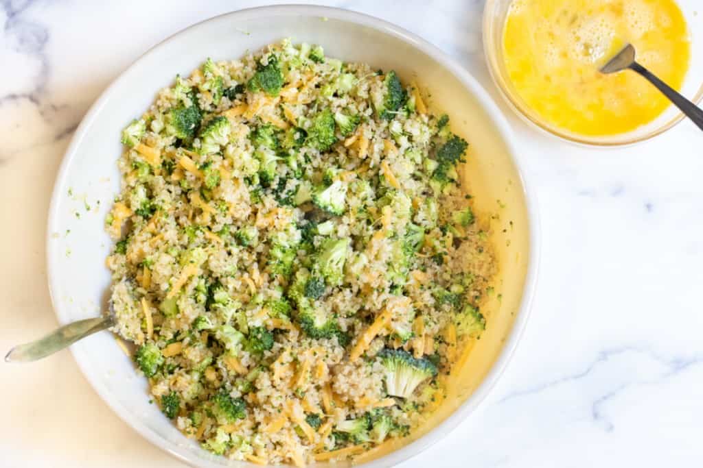 a large bowl with quinoa, broccoli, and cheese and then a bowl of whisked eggs.