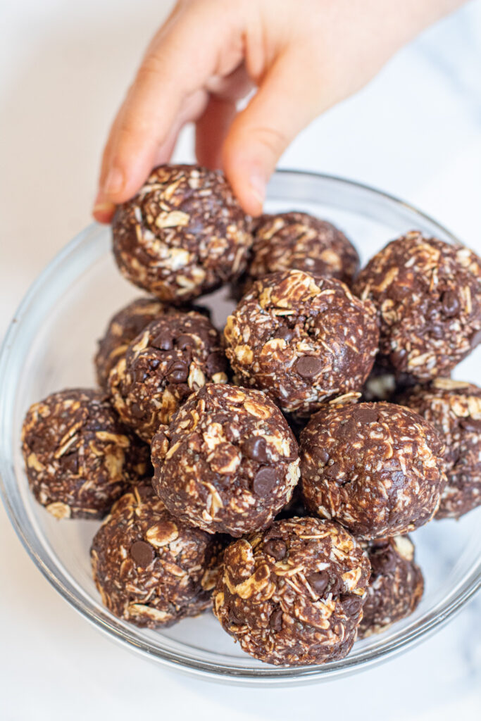 kids hand grabbing a peanut butter energy ball.