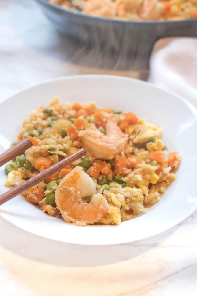 cauliflower shrimp fried rice in a bowl with chopsticks