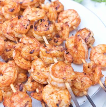 skewers with grilled shrimp on a plate.