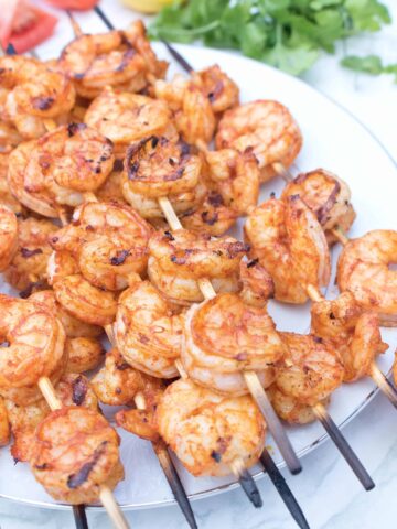 skewers with grilled shrimp on a plate.