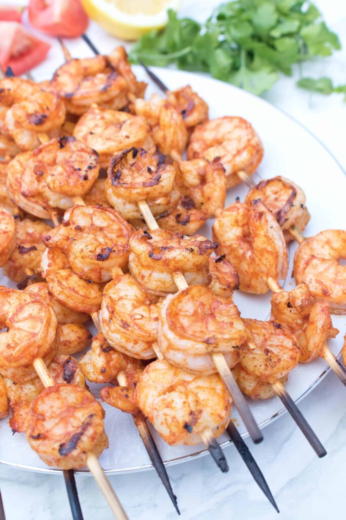 skewers with grilled shrimp on a plate.