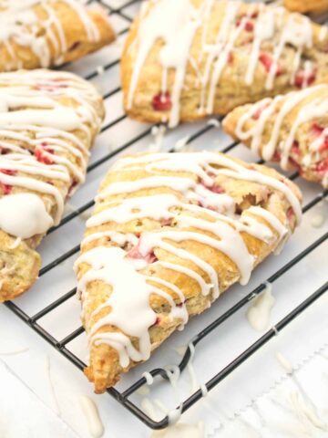 glazed scones with strawberries on a cooling rack