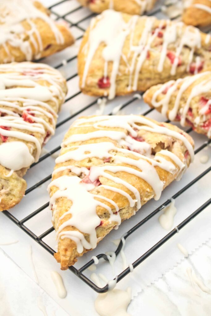 glazed scones with strawberries on a cooling rack