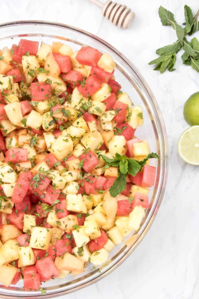 a bowl of pineapple, watermelon, and mint.