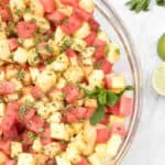 a bowl of pineapple melon and watermelon with mint.