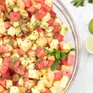 a bowl of pineapple melon and watermelon with mint.