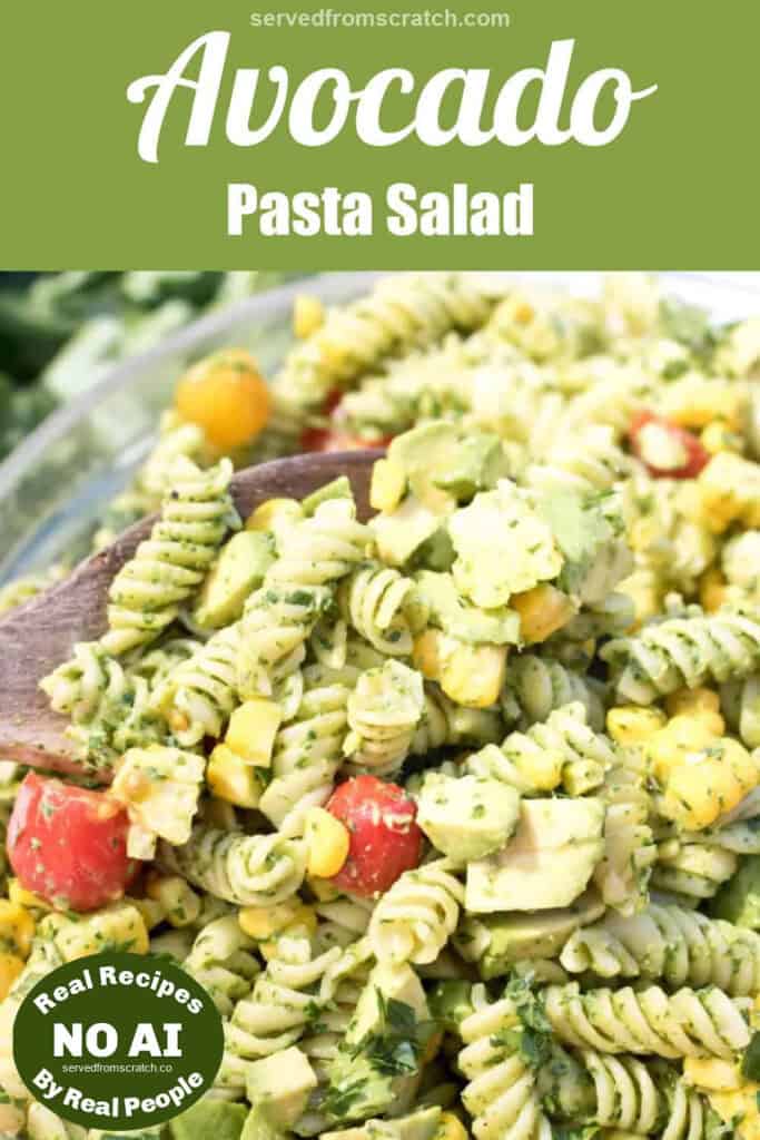 green pasta salad with tomatoes and corn with a wooden spoon in it with Pinterest pin text and NO AI sticker.