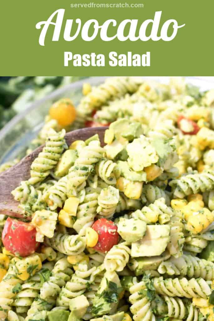 a close up of a green pasta salad with tomatoes and corn and Pinterest pin text.