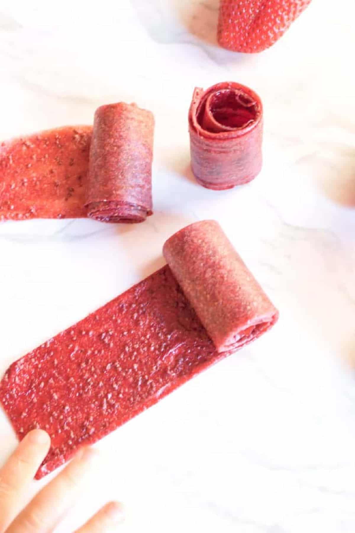 some rolled up strawberry fruit roll ups.