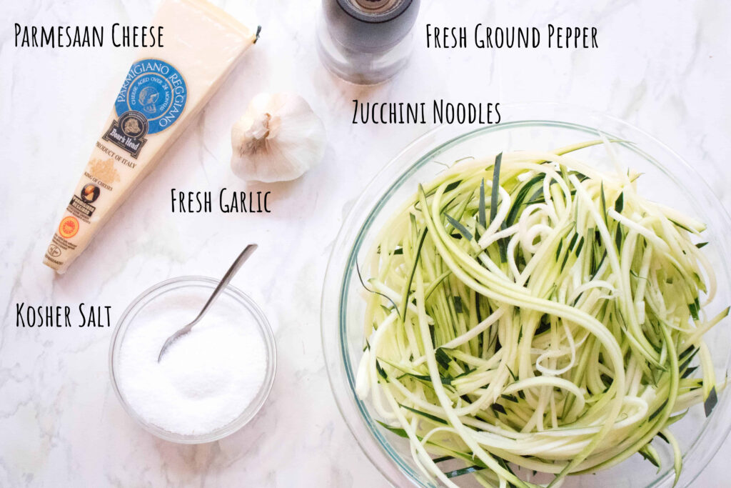 parmesan cheese, salt, fresh garlic, pepper grinder, and zoodles