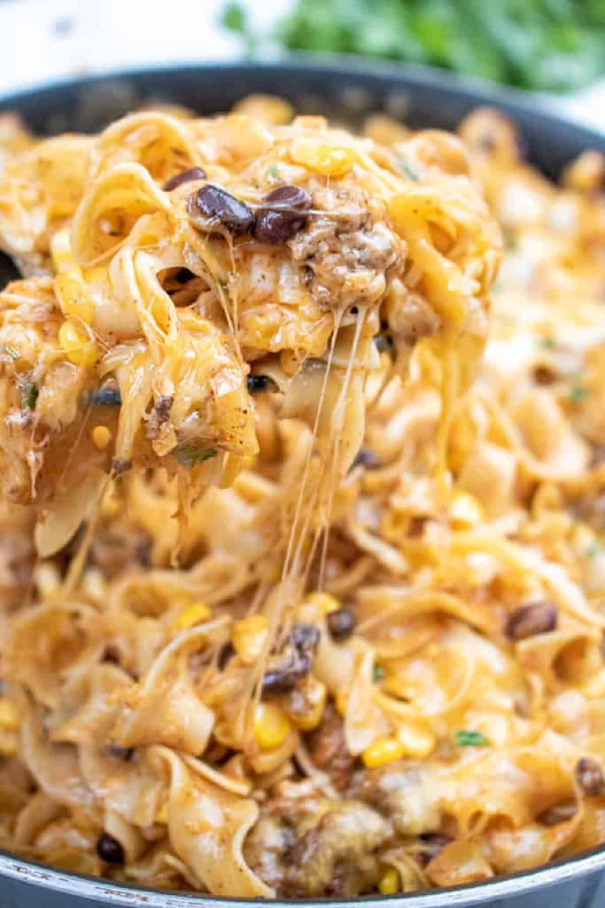 a spoon scooping up cheesy pasta.