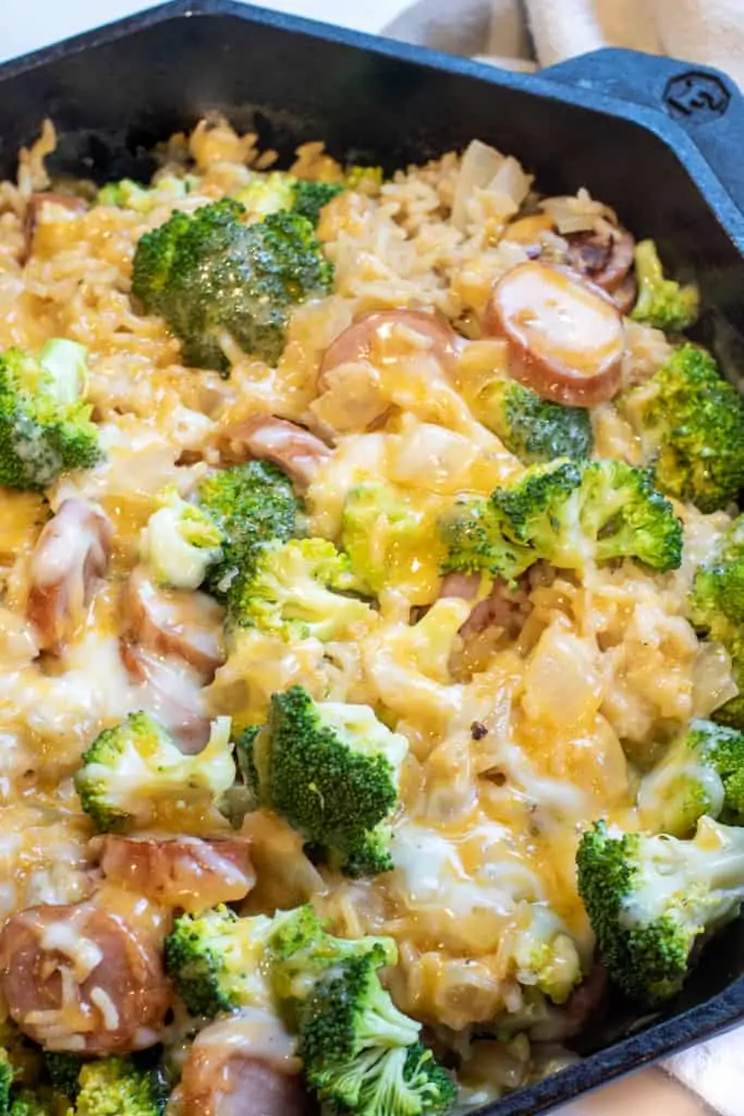 a pan with broccoli cheese, kielbasa, and rice.