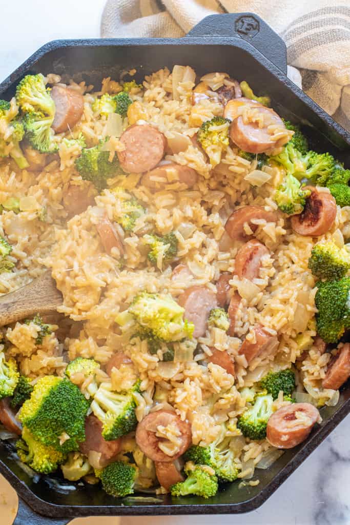 a pan with broccoli cheese, kielbasa, and rice.