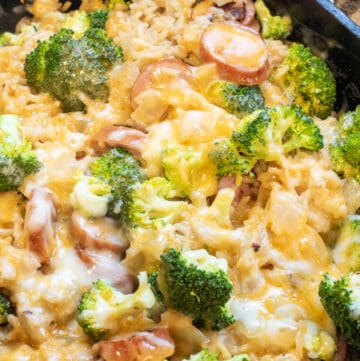 a pan with broccoli cheese, kielbasa, and rice.