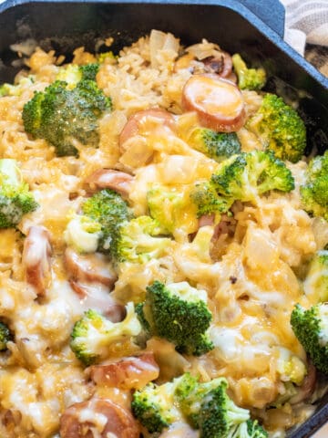 a pan with broccoli cheese, kielbasa, and rice.