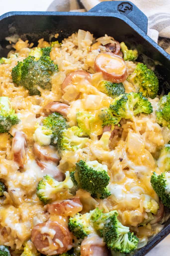 a pan with broccoli cheese, kielbasa, and rice.