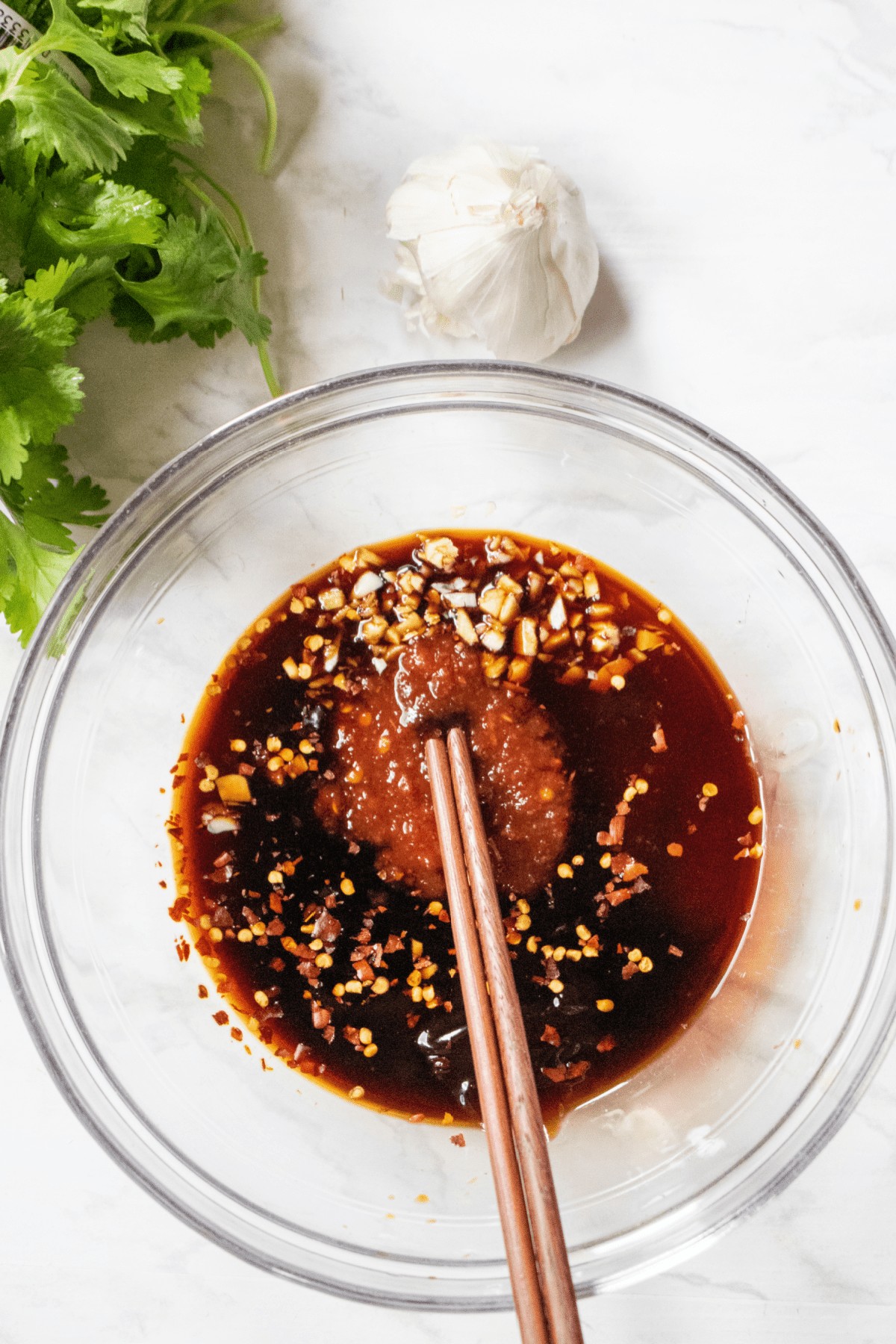 a bowl with soy hoisin and chili garlic sauce and chopsticks.