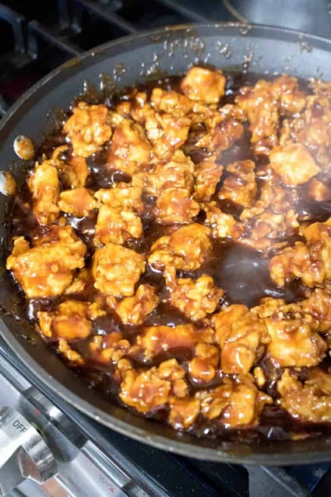 a pan of crispy fried chicken in sauce.