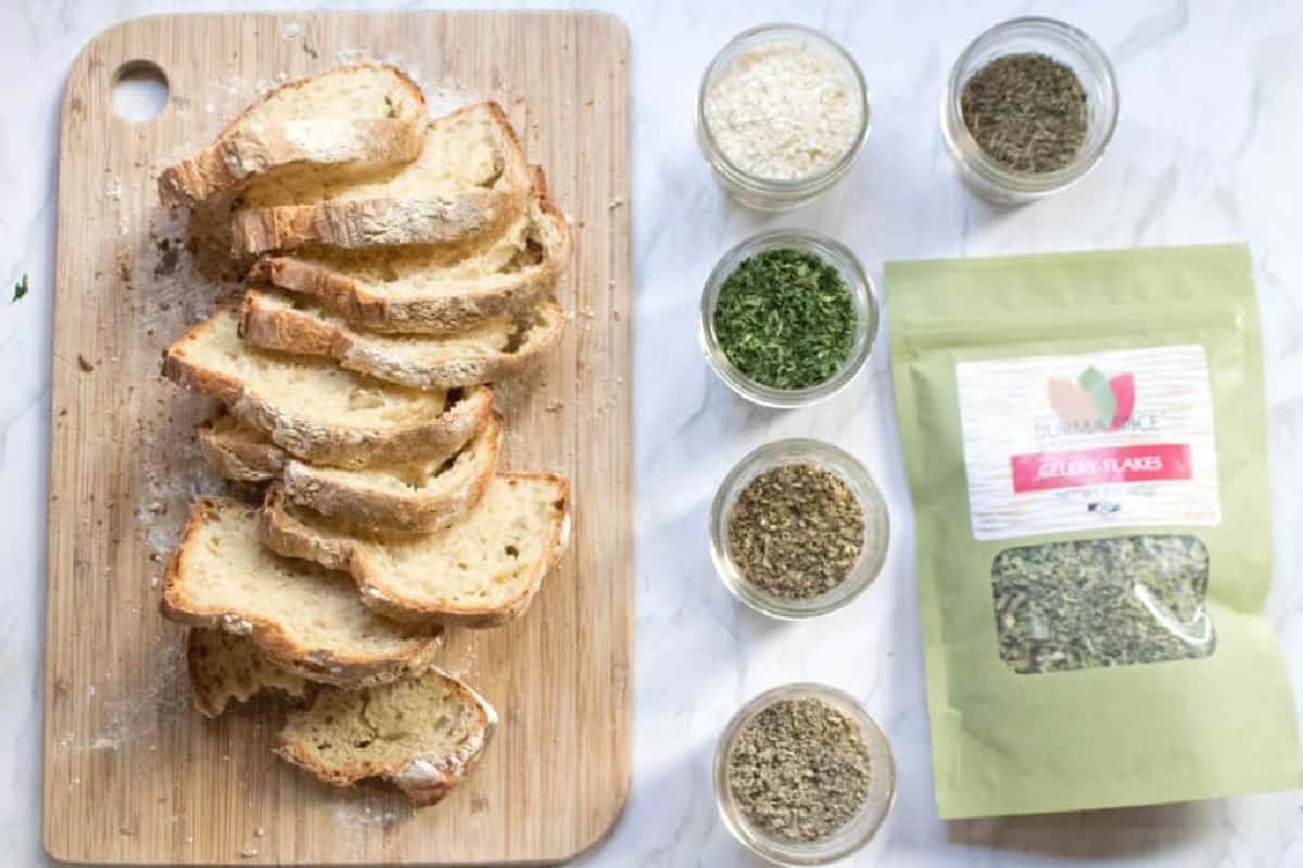 a cutting board of sliced stale bread next to a bunch of spices. 