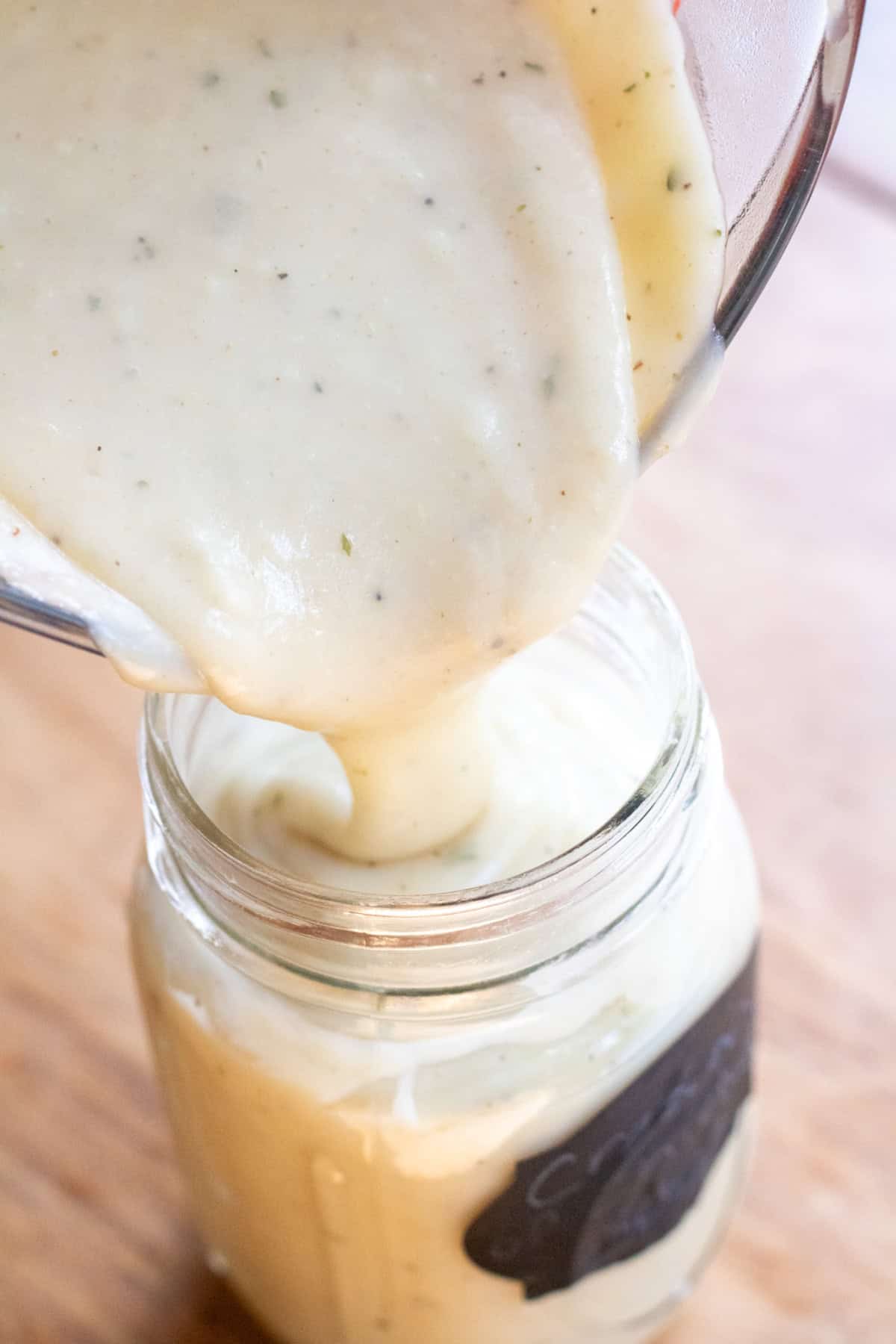 a creamy soup being poured into a mason jar.
