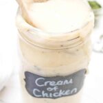 a large mason jar of creamy soup with a wooden spoon