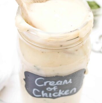 a large mason jar of creamy soup with a wooden spoon