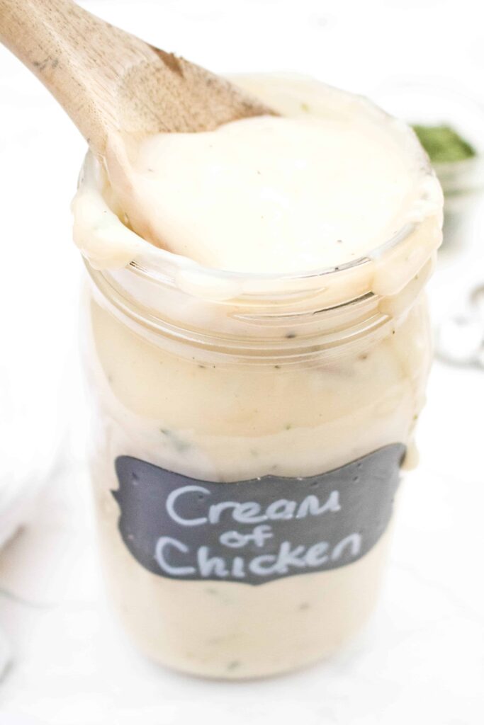 a large mason jar of creamy soup with a wooden spoon