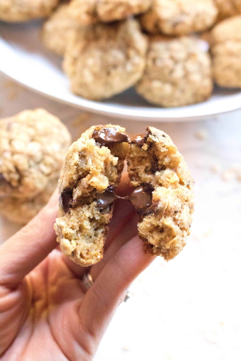 a hand holding a cookie with melted chocolate chips in half