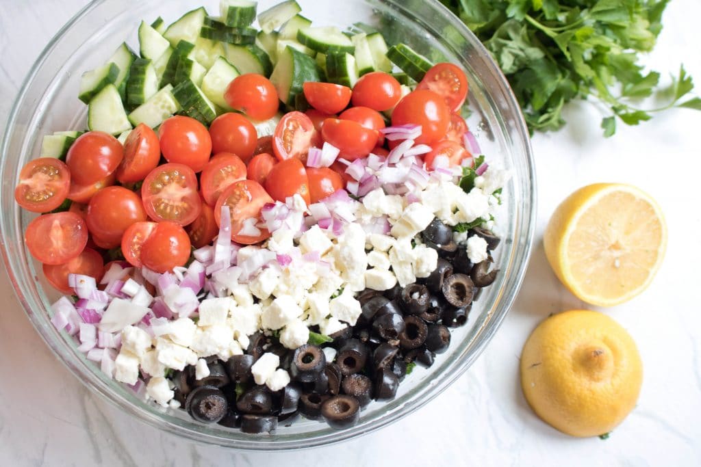 bowl with kale, tomatoes, cucumbers, feta, and chickpeas.