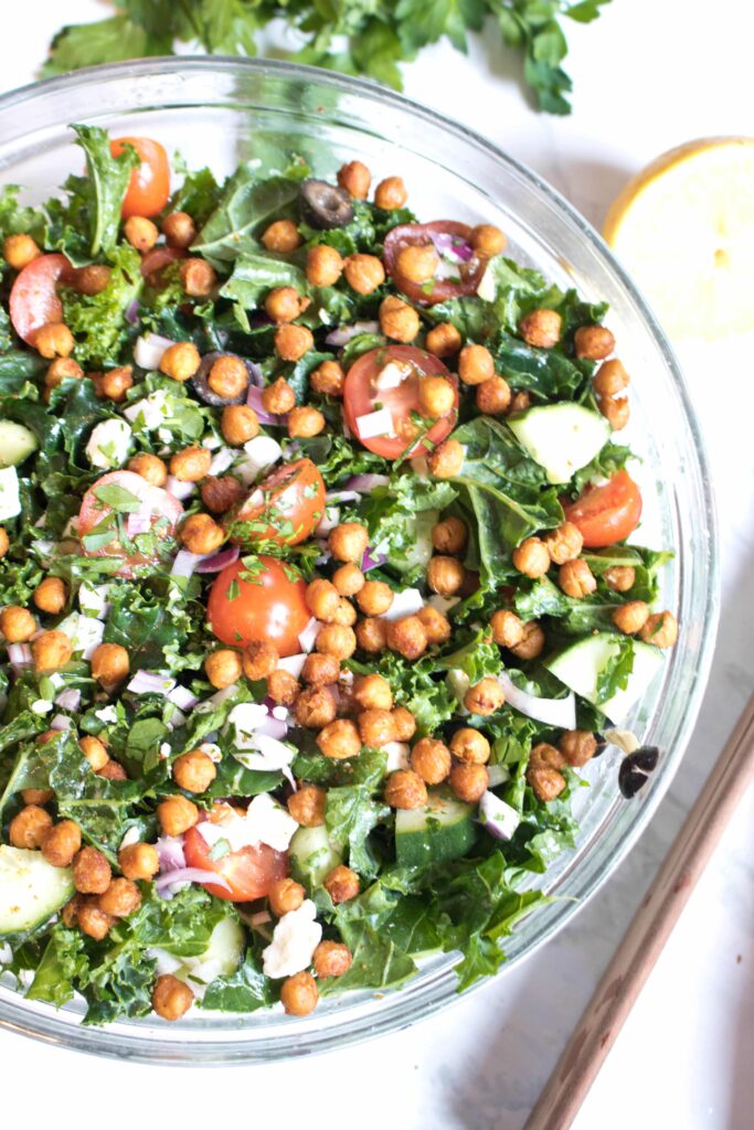 bowl with kale, tomatoes, cucumbers, feta, and chickpeas.