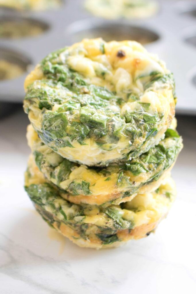 3 stacked egg cups with spinach and feta.