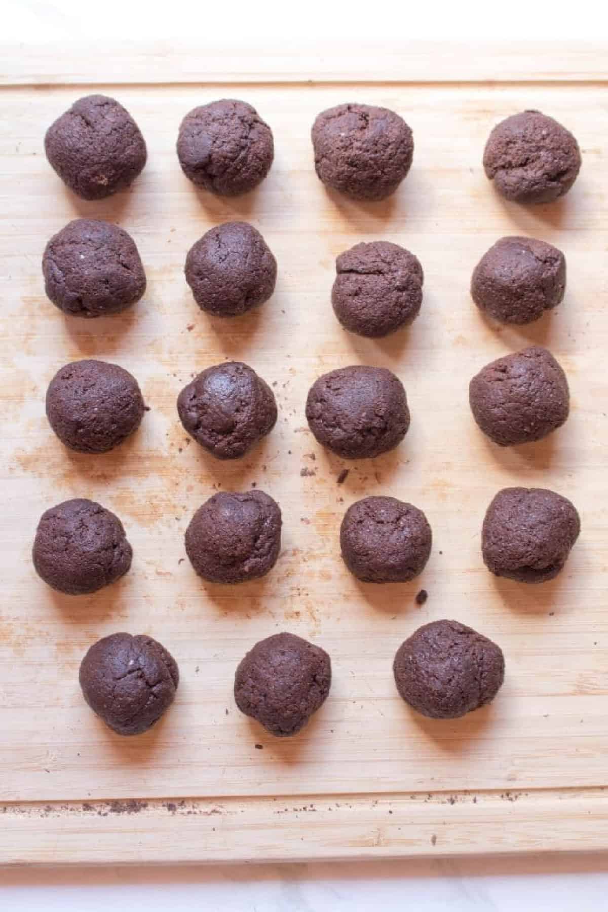 balls of chocolate dough on a cutting board.