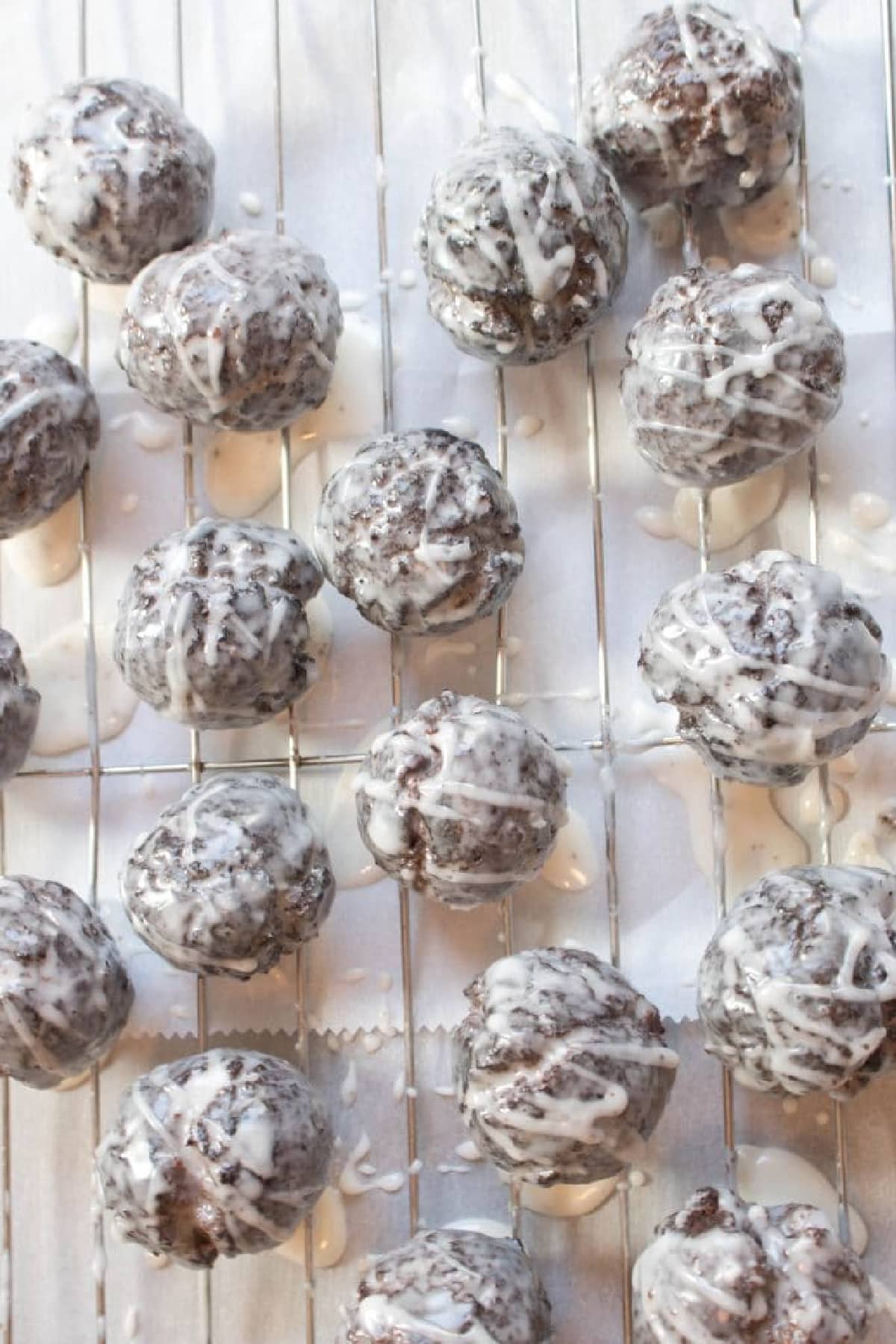 a cooling rack full of glazed chocolate munchkins.