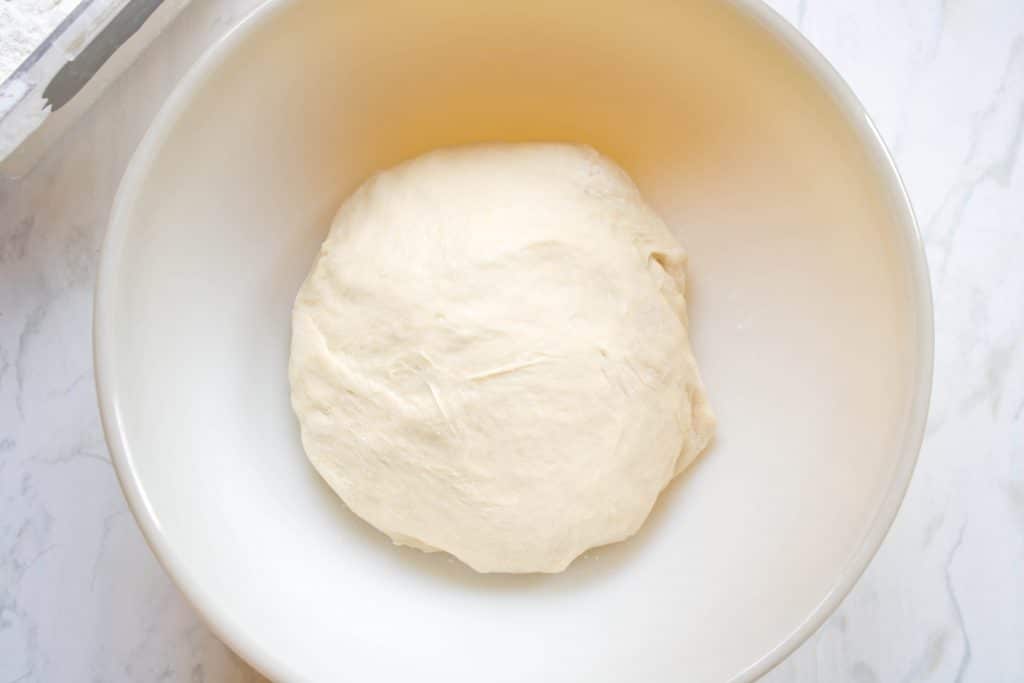 overhead of a round dough in bowl.