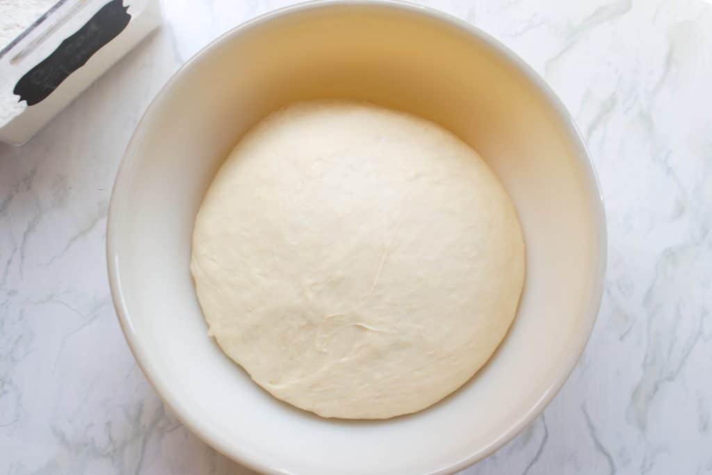 overhead of a proofed dough in bowl.