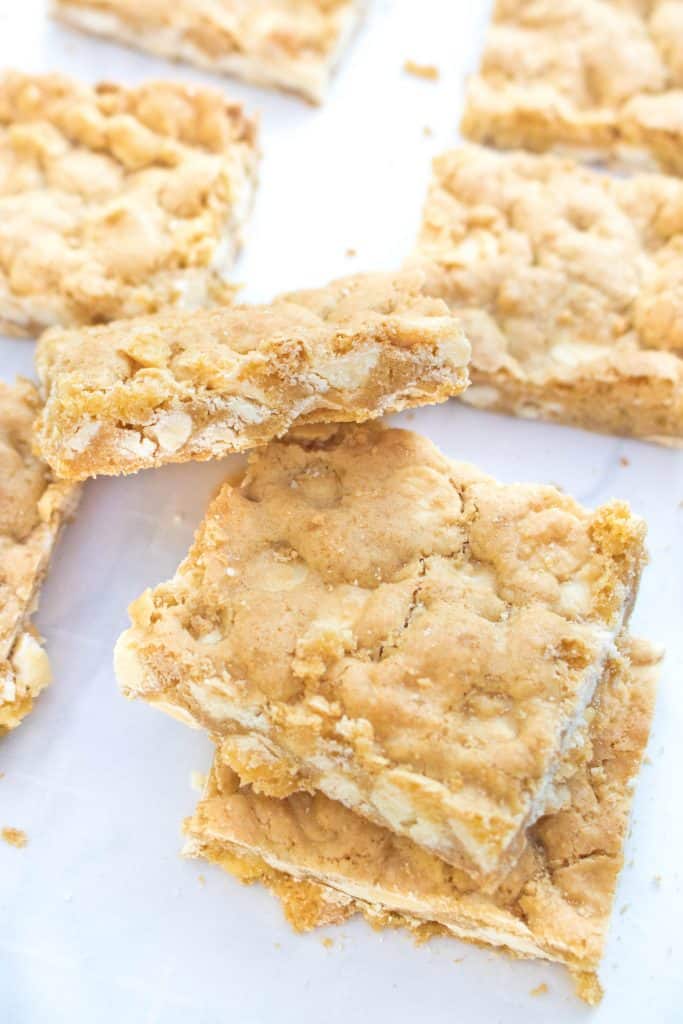 baked white blondies stacked and on parchment paper