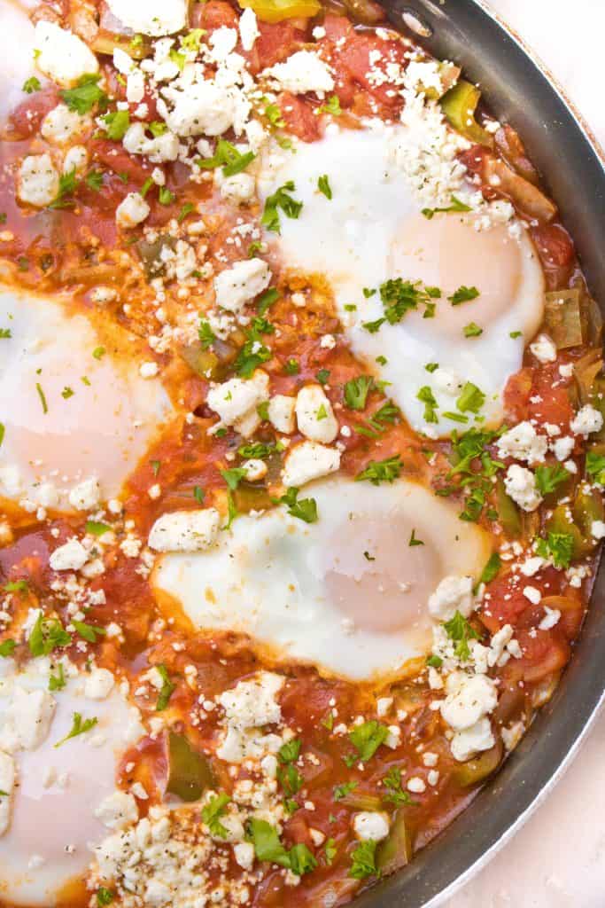 an overhead of baked eggs in a tomato sauce