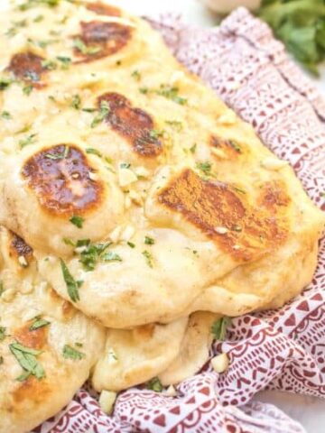 naan with melted butter and garlic on a red napkin.