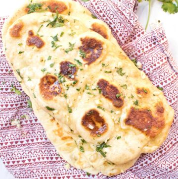 naan with melted butter and garlic on a red napkin.