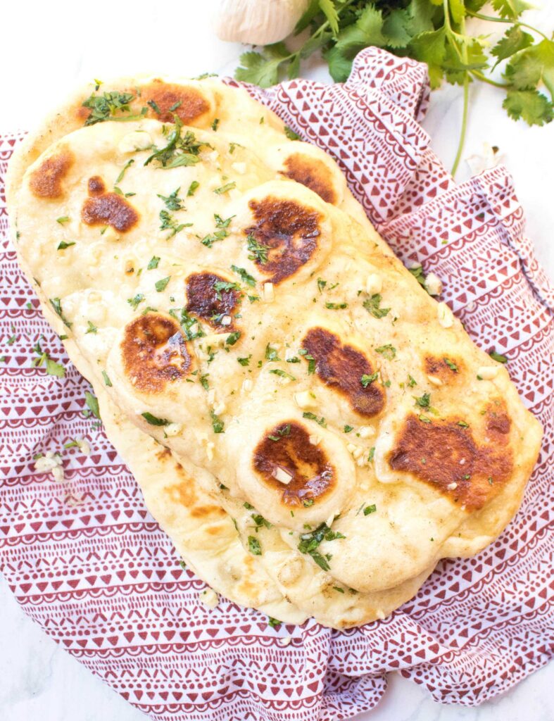 cooked garlic flatbread on a red napkin.