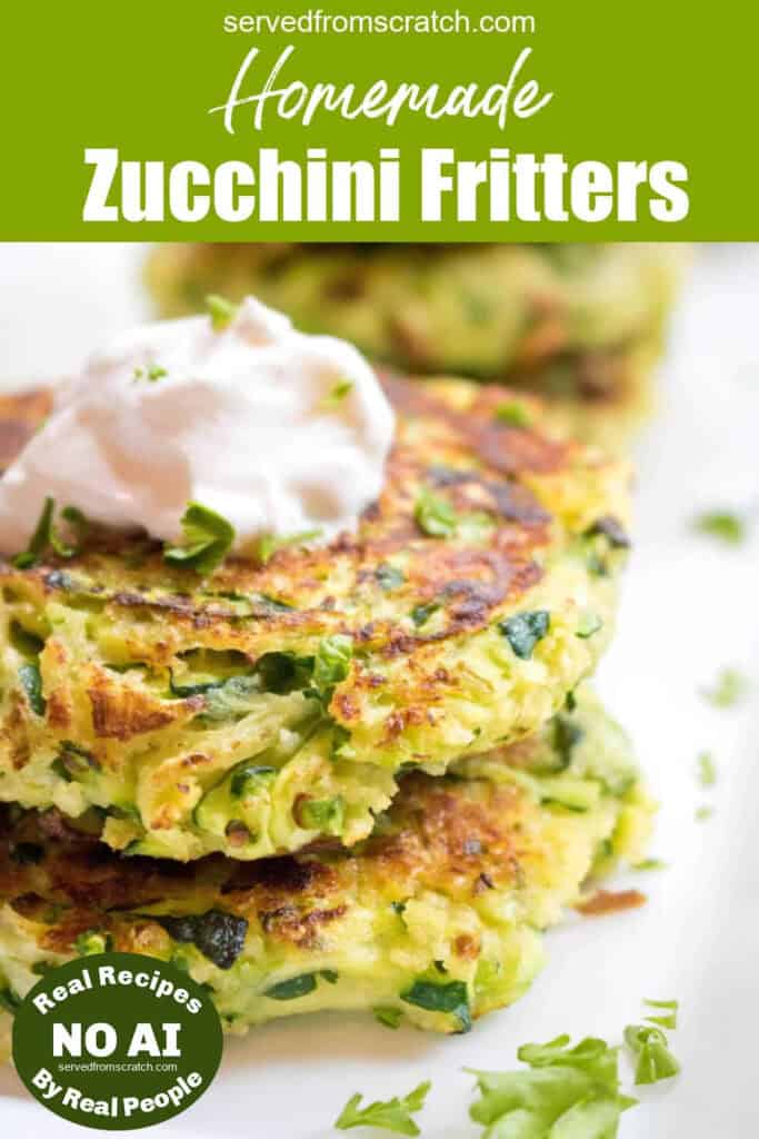 a stack of cooked zucchini fritters with a dollop of sour cream on top with Pinterest pin text and NO AI sticker.