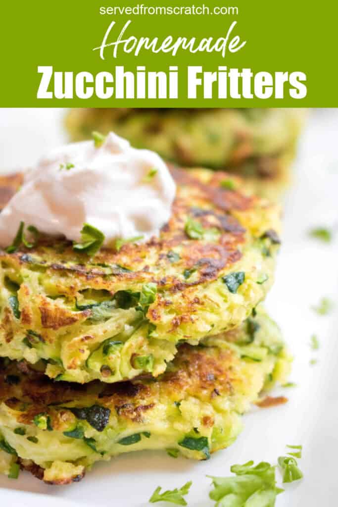 a close of up of stacked zucchini fritters topped with sour cream with Pinterest pin text.