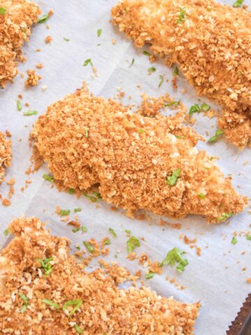 crispy baked panko crusted chicken tenders on parchment paper