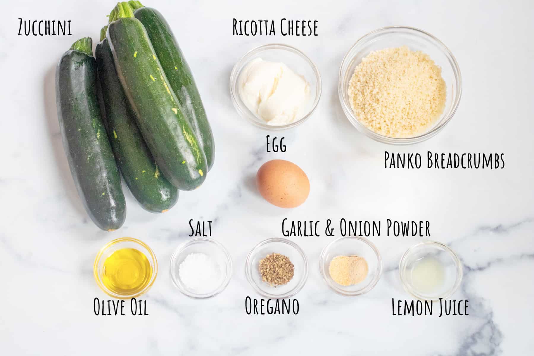 zucchinis, ricotta, panko, egg, spices, and oil in small bowls.
